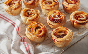 Puff pastry dough swirled with French onion soup flavor displayed on a countertop.